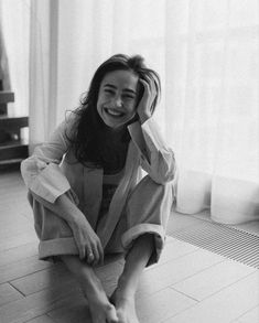 a black and white photo of a woman sitting on the floor