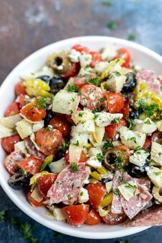 a white bowl filled with lots of different types of food on top of a table