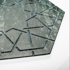 a gray and black hexagonal tile with lines in the shape of letters on it