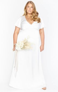 a woman in a white dress holding a bouquet