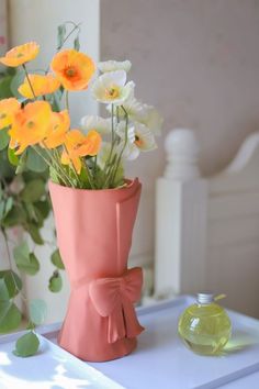 a pink vase with yellow and white flowers in it