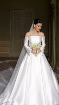 a woman in a white wedding dress holding a bouquet