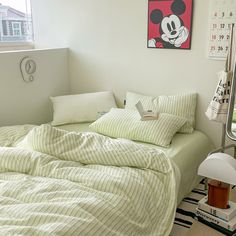 a bedroom with a mickey mouse painting on the wall and bed in front of it