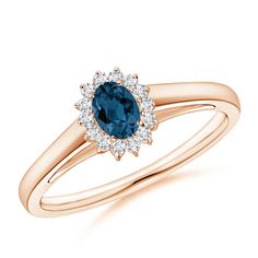 a yellow gold ring with an oval blue sapphire and diamonds