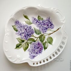 a white plate with purple flowers painted on it