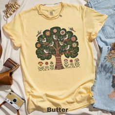 🌲✨ Embrace Scandinavian charm with this unique folk art T-shirt featuring birds and a floral tree design. Perfect for nature lovers and garden enthusiasts! 🌸🕊️  Comfort Colors 1717 is a fully customizable tee made 100% with ring-spun cotton. The soft-washed, garment-dyed fabric brings extra coziness to your wardrobe while the relaxed fit makes it an excellent daily choice. The double-needle stitching throughout the tee makes it highly durable while the lack of side-seams helps the shirt retai Nature-inspired Cotton T-shirt With Screen Print, Nature-inspired Cotton T-shirt For Spring, Nature-inspired Short Sleeve T-shirt For Summer, Nature-inspired Cotton Tops With Screen Print, Nature-inspired Cotton Tops With Graphic Print, Spring Nature-inspired Cotton T-shirt, Cottagecore Cotton Printed T-shirt, Spring Nature-inspired Short Sleeve T-shirt, Cottagecore Printed Cotton T-shirt