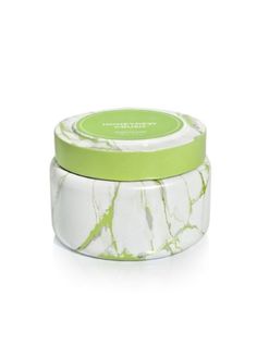 a green and white jar with a lid on it that is sitting on a white surface