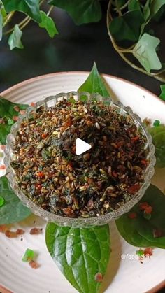 a white plate topped with lots of green leaves