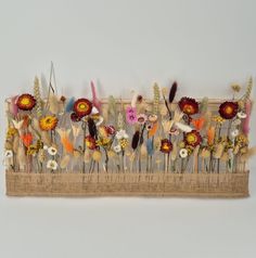 a bunch of flowers that are sitting on a piece of burlock with feathers