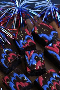 some brownies with red, white and blue frosting on top of a wooden table