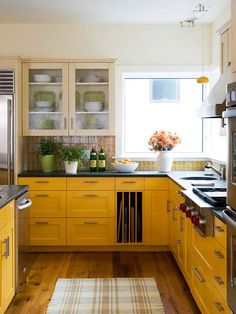 a kitchen with yellow cabinets and stainless steel appliances