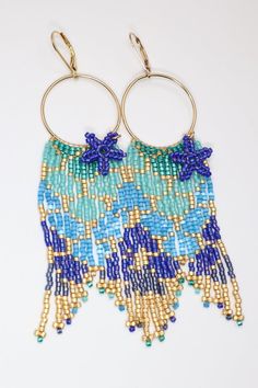 Have you heard the mermaids calling? Our new mermaid tail seed bead hoop earrings are calling to you too.  Add a touch of magic to your day with our hand beaded earrings in iridescent bright colors.  They feature starfish dangles and jeweled fins.  Made with premium delica seed beads and gold filled hoops & lever b Gold Beaded Hoop Earrings For The Beach, Ocean-inspired Colorful Beaded Summer Jewelry, Summer Dangle Hoop Earrings With Tiny Beads, Starfish-shaped Beaded Jewelry For The Beach, Bohemian Starfish Charm Jewelry For Crafting, Bohemian Starfish Charm Jewelry For Jewelry Making, Summer Beaded Starfish Jewelry, Dangle Hoop Earrings With Tiny Beads For Beach, Bohemian Jewelry With Starfish Charm For Jewelry Making