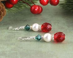 Beautiful 2 inch crystal drop Christmas earrings in .925 sterling silver. These earrings are created with white Swarovski pearls, Swarovski Austrian crystals, red Czech glass beads, and silver-plated crystal spacers, and sterling earwire components. These beads are so adorable and sparkling. Length: 2 inch Bead size: 10 mm, 8 mm, and 6 mm Materials: Swarovski Austrian crystals Metals: .925 sterling silver Color: red, white, green Closure: Earwire These crystal beaded earrings are made in the USA Cheap Silver Christmas Earrings, Cheap Holiday Drop Earrings, Christmas Earings, Diy Christmas Earrings, Christmas Jewelry Diy, Crystals Red, Diy Earrings Easy, Christmas Jewellery, Holiday Earrings