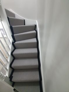 an image of a staircase going up to the top floor with carpet on both sides