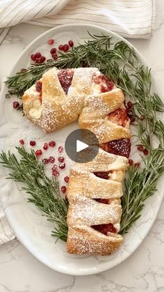 a white plate topped with pastries covered in powdered sugar and cranberries