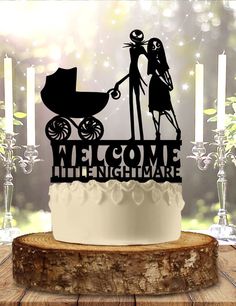 a cake topper with a silhouette of a man and woman holding a baby carriage