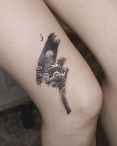 a woman's leg with a tattoo on it that has an image of a mountain