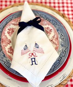 a red, white and blue place setting with an american flag napkin on the plate