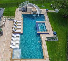 an aerial view of a swimming pool with lounge chairs and umbrellas in the grass