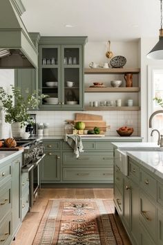 a kitchen filled with lots of green cabinets and counter top space next to a rug