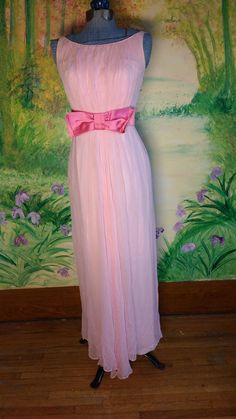 "This adorable cotton candy color dress does not have a label so it is hard to place the era, but it has a metal zipper and the style places it from between circa 1960s.  This dress has beautiful lines and the chiffon outer layer is ruched on the font which is carried down the front of the skirt causing a cascade effect.  The fucha ribbon around the waist and bow in the front is absolutely darling.    It is in fair to good vintage condition. It has very slight yellowing around the arm holes. and Pink Vintage Dress For Summer Party, Pink Vintage Dress For Party, Spring Pink Dresses For Vintage Events, 1950s Style Pink Party Dress, Pink 1950s Evening Dress, Pink Lined Vintage Dress, Vintage Spring Prom Dresses, Spring Vintage Prom Dresses, Pink 1950s Style Formal Dress