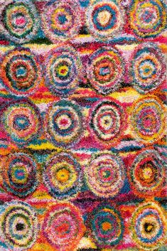 a multicolored area rug with circles on the top and bottom in different colors