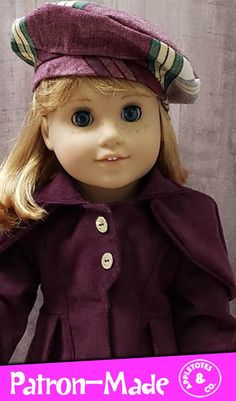 a doll with blonde hair wearing a purple coat and matching hat, standing in front of a wall