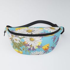 a blue fanny bag with white daisies and yellow butterflies on the front, against a light blue background