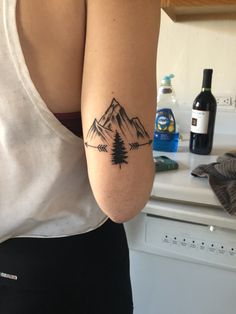 a woman with a mountain tattoo on her arm