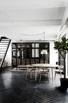 an image of a living room with black and white decor on the walls, stairs to the second floor