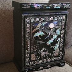 an ornate black cabinet sitting on top of a couch