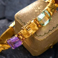 This colorful fancy link bracelet is accented with one (1) natural amethyst, two (2) natural citrine, one (1) natural aquamarine, one (1) natural green tourmaline and one (1) natural prasiolite set into four-prong settings. The gold links have a brushed finish that plays with the light beautifully. The bracelet fits p to a 6.75 inch wrist and is finished with a hidden box clasp and figure eight safety. Luxury Yellow Gold Multi-stone Bracelet, Amethyst Bracelet In Fine Jewelry Style, Luxury Yellow Gold Multi-stone Bracelets, Luxury Amethyst Multi-stone Jewelry, Luxury Multi-stone Amethyst Jewelry, Luxury Gemstone Accented Bracelet Jewelry, Yellow Gold Gemstone Accented Bracelet, Gold Amethyst Bracelets For Formal Occasions, Luxury Yellow Gold Bracelets With Natural Stones