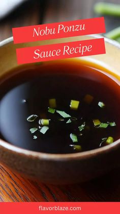 a bowl filled with soup sitting on top of a wooden table next to green beans