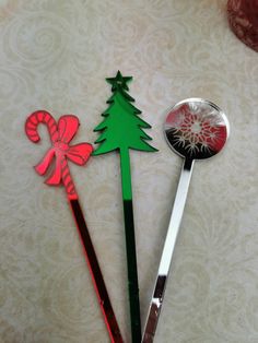 three christmas tree shaped spoons sitting next to each other on top of a table