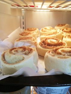 cinnamon rolls sitting on top of a pan in the oven