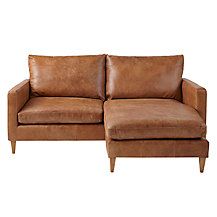 a brown leather couch sitting on top of a white floor