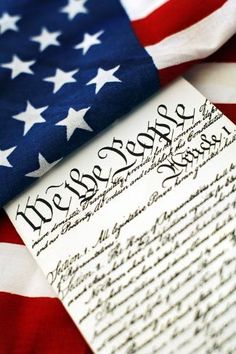 an american flag with the declaration of the united states on it, next to a piece of paper