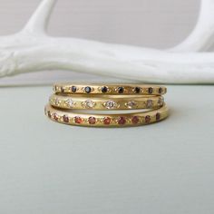 Champagne, cognac and black diamond bands - which would you choose? Elegant Luxury Ethical Gemstones Stackable Rings, Modern Stackable Rings With Ethical Gemstones In 14k Gold, Luxury Yellow Gold Stackable Rings In Recycled Gold, Gold Stackable Rings In Recycled Gold, Fine Jewelry, Luxury Multi-stone Enamel Ring, Black Diamond Bands