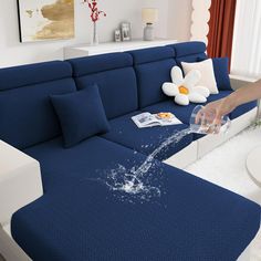 a blue couch with water splashing out of it's back end and arm