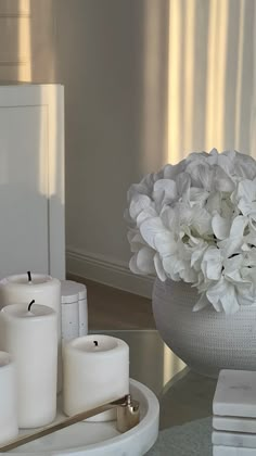 white flowers and candles are sitting on a table