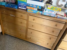 a wooden dresser topped with lots of children's books and toys on top of it