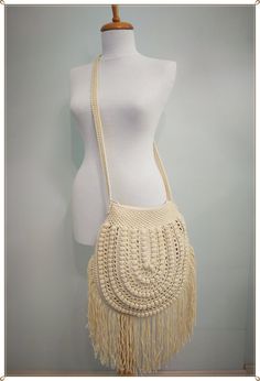 a white crocheted purse on a mannequin