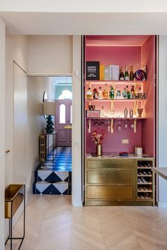 a room with pink walls and shelves filled with bottles