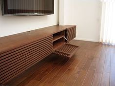 a tv mounted on the wall in a living room with hardwood floors and hard wood flooring