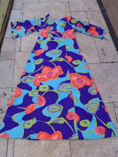 1970's Hawaiian Print Maxi Dress by Tori Richard Honolulu Polyester Fabric/Feels like Combed Cotton Purple, Blue, Pink Orange and Green Multicolor Fabric 4 Front Decorative Buttons 23 Inch Back Zipper SIZE: Medium/Large MEASUREMENTS (in inches): Shoulder to Shoulder from the back 20 Bust: 38 Waist: 36 Underarm to hem 44 Underarm to cuff 13 Sleeve Openings 10 Neck Opening: 26 Front 4 Inch V Split Back of the neck to hem 53 INTERNATIONAL CUSTOMER?? Please email for Shipping Info Retro V-neck Lined Maxi Dress, 1970s Style Multicolor Maxi Dress, Retro Lined Maxi Dress, Retro Blue Spring Maxi Dress, Retro Blue Maxi Dress For Spring, Blue Retro Maxi Dress For Spring, Vintage Blue Maxi Dress For Spring, Blue Retro Dress With Vintage Print, Blue Vintage Maxi Dress For Spring