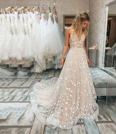 a woman in a wedding dress looking at dresses