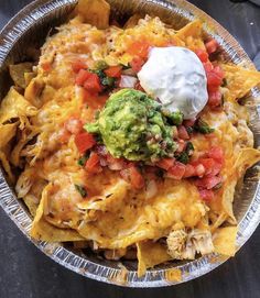 nachos with guacamole and sour cream on top