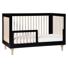 a baby crib with white sheets and wooden slats on the sides, in front of a white background