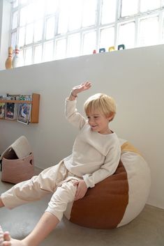 a young boy sitting on top of a bean bag chair