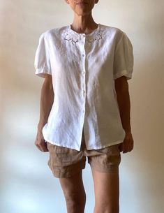 Very beautiful white shirt, made by a seamstress in 100% linen and hand embroidered. (label in Italian: "pure linen, hand embroidered" adorable details: the buttons covered with white fabric; a change button inside pretty puffed sleeves are also embroidered Size: Medium / Large Check with your measurements the model is a Small and measures 1m72 / 5.7' Shirt: - shoulder to shoulder 46 cm / 18" - bust 114 cm / 45" - length 68 cm / 27" Very good condition, fine and quality work **For shipping worldwide, phone number is required, thank you Delivery for France is free via Mondial Relais. Please specify your relay point in a message. Instagram for videos and news: @marinadeprovencevintage Short Sleeve Linen Blouse With Floral Embroidery, White Linen Top With Broderie Anglaise, White Linen Top With Broderie Anglaise Detail, Linen Embroidered Button-up Top, Embroidered Linen Button-up Top, Linen Button-up Top With Embroidery, Daywear Embroidered Linen Blouse, Embroidered Linen Blouse For Daywear, Fitted Linen Blouse With Floral Embroidery